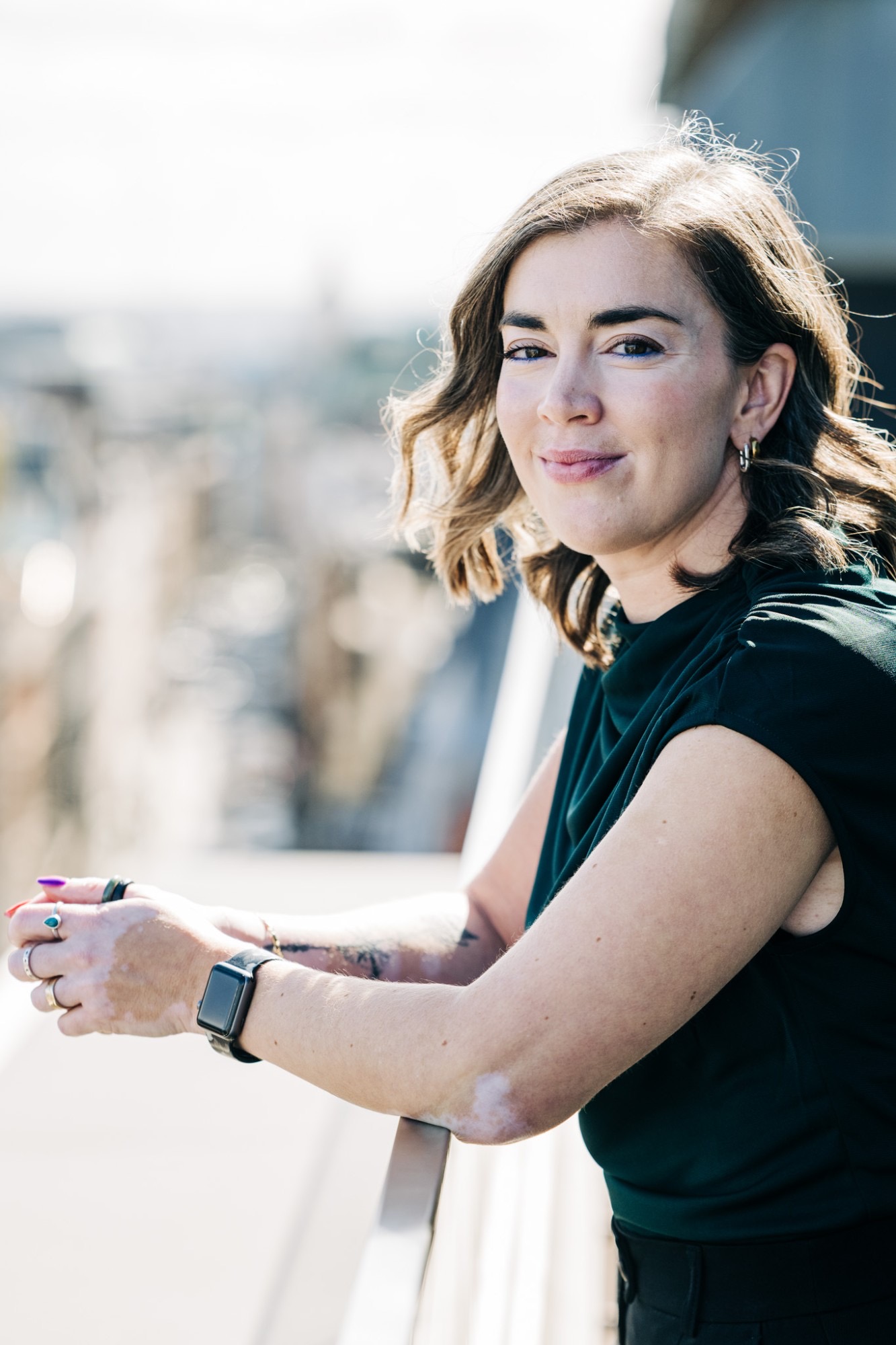 Jancis Dunn smiling on a rooftop balcony above the city