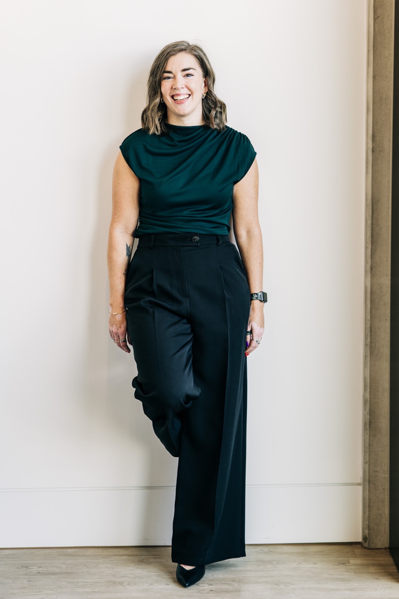 Jancis Dunn standing against a white wall, laughing